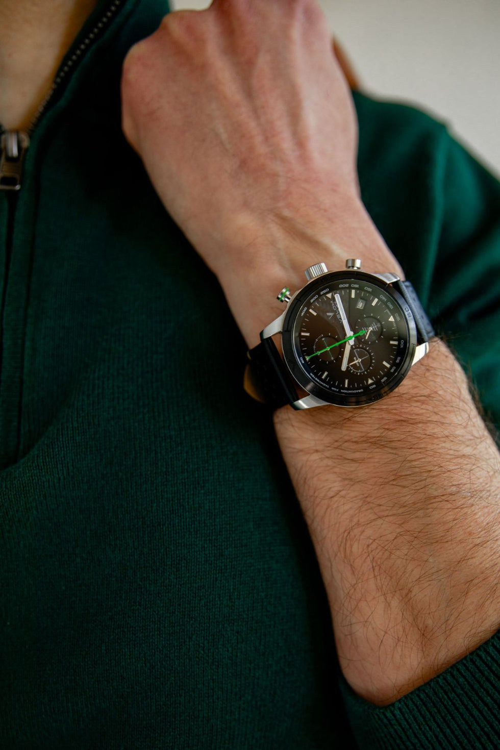 montre noir et verte, pull vert bracelet cuir perforé noir